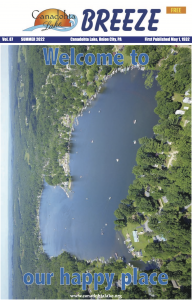 Cover of the Canadohta Lake Breeze, an Aerial photo of a lake surrounded by trees "our happy place"